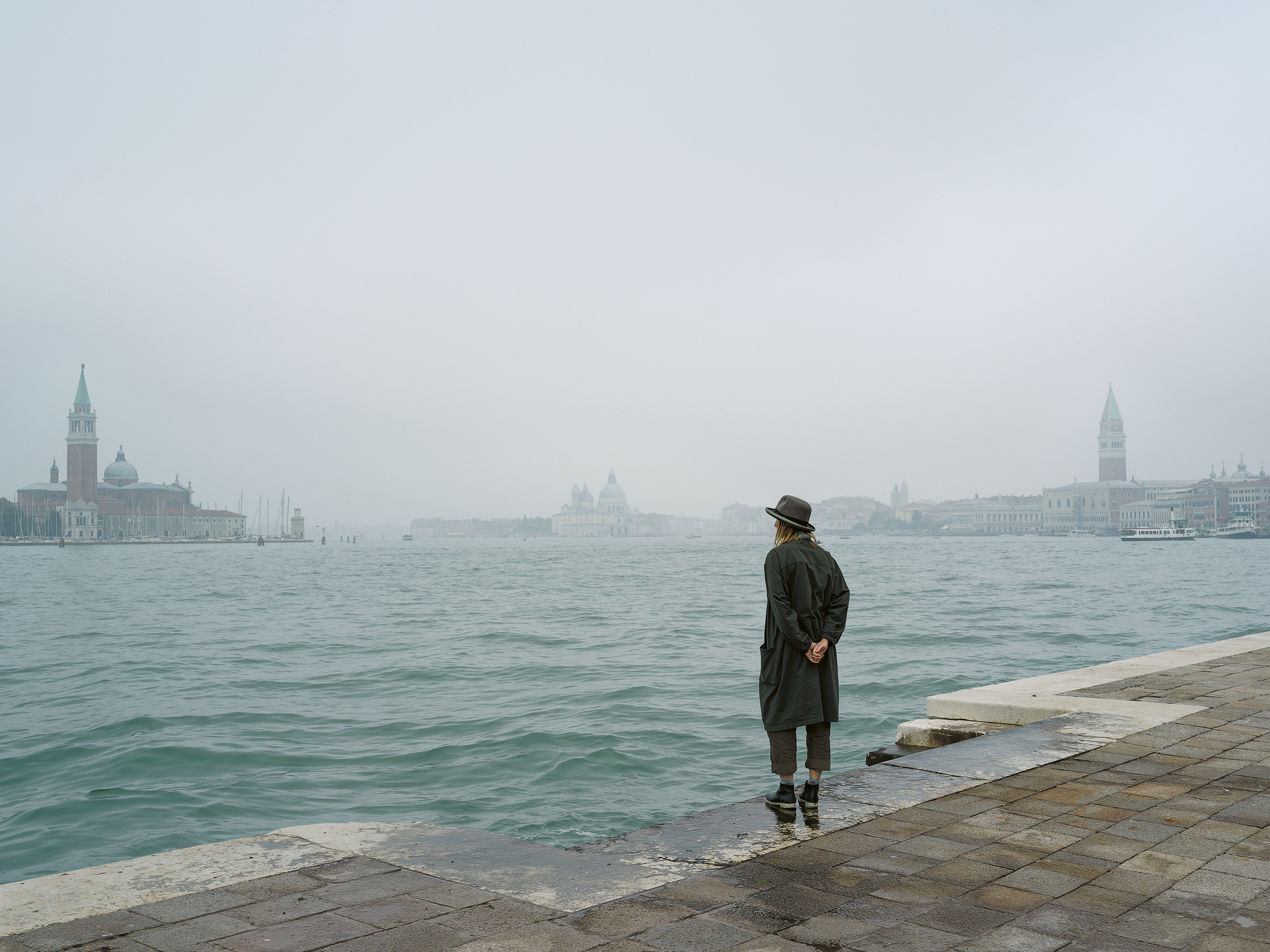 photograph by the artist Elina Brotherus, dressed as the artist Joseph Beuys, looking out on the water in Venice