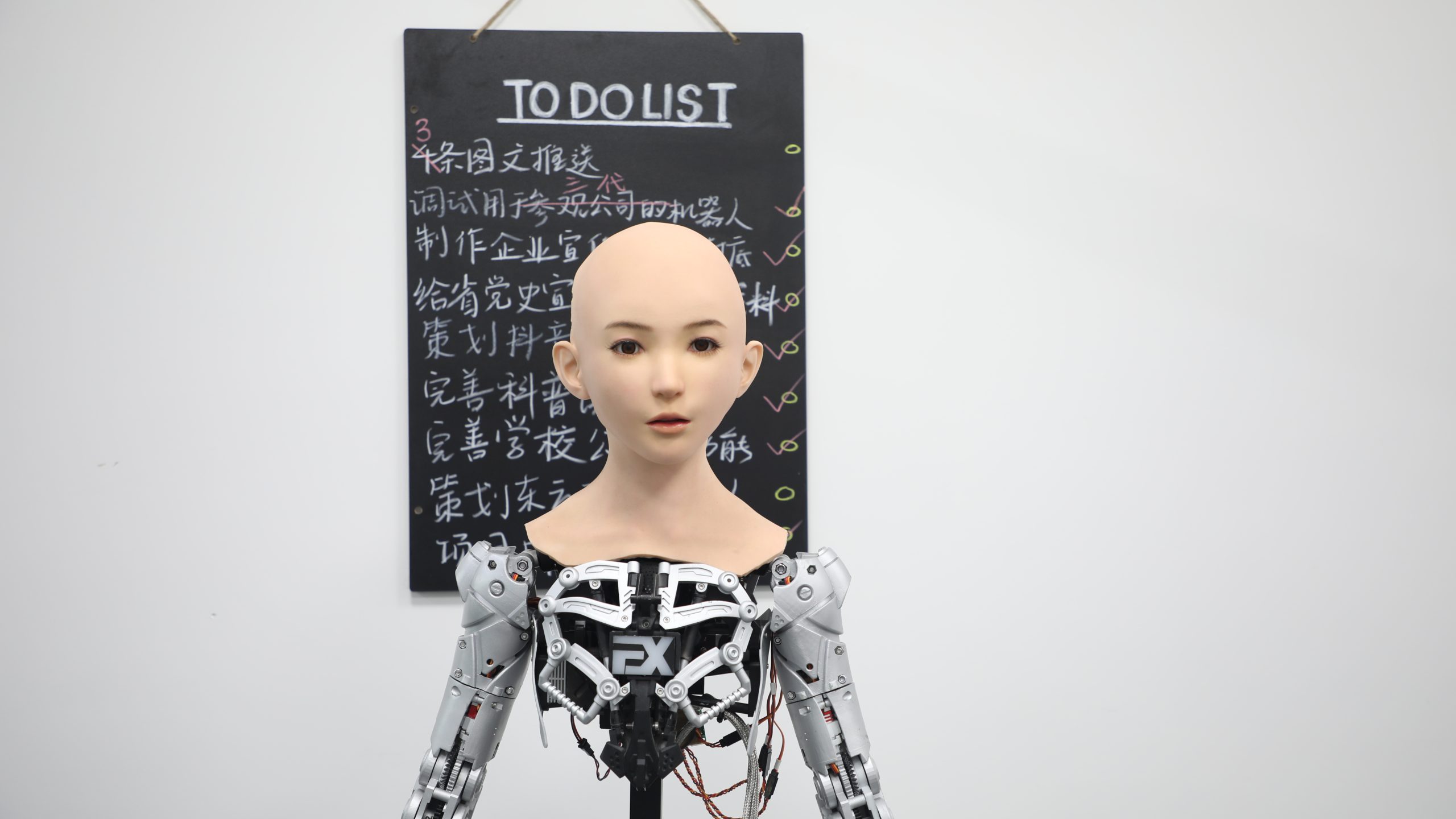 photograph of a robot with a chalk board in the background, reading 'to do list'