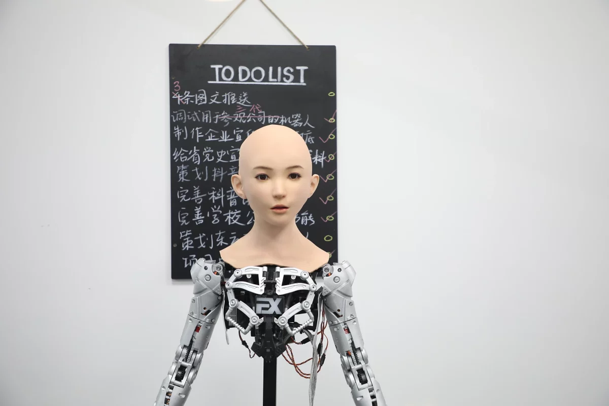 photograph of a robot with a chalk board in the background, reading 'to do list'