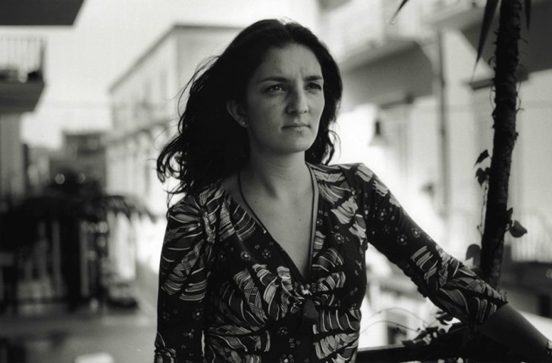 black and white film still showing a woman with long hair in a city