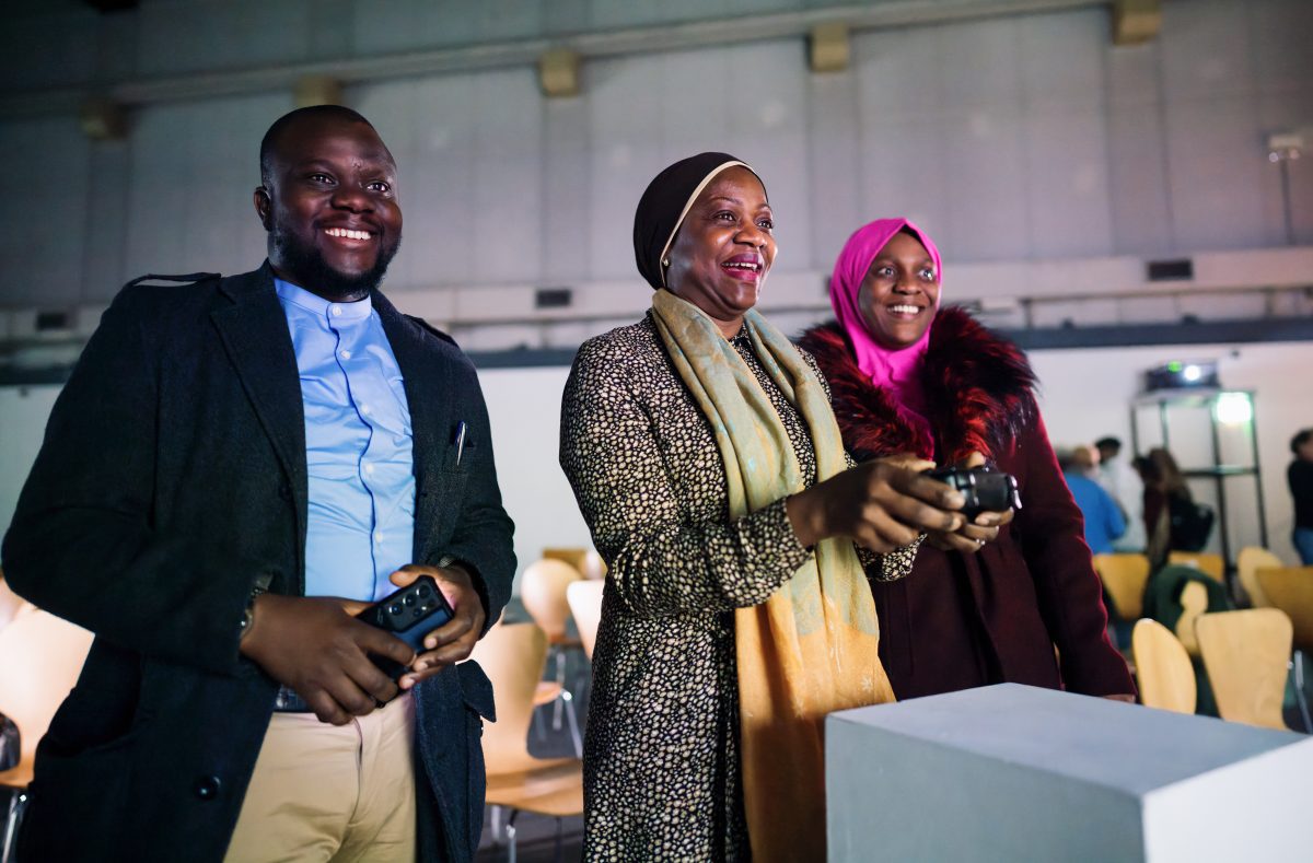 Three people interacting with 3D model using gamepad