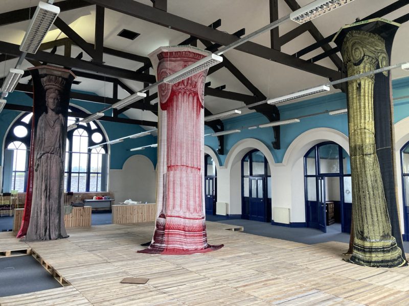 photograph showing a theatre set with a large pink column in the middle