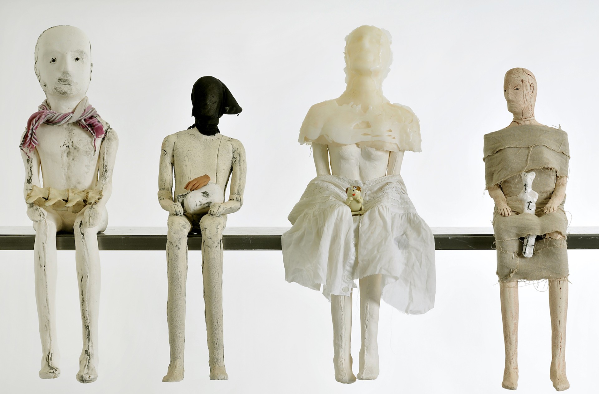 photograph of 4 clay figures sitting on a ledge. Figures made by Christie Brown